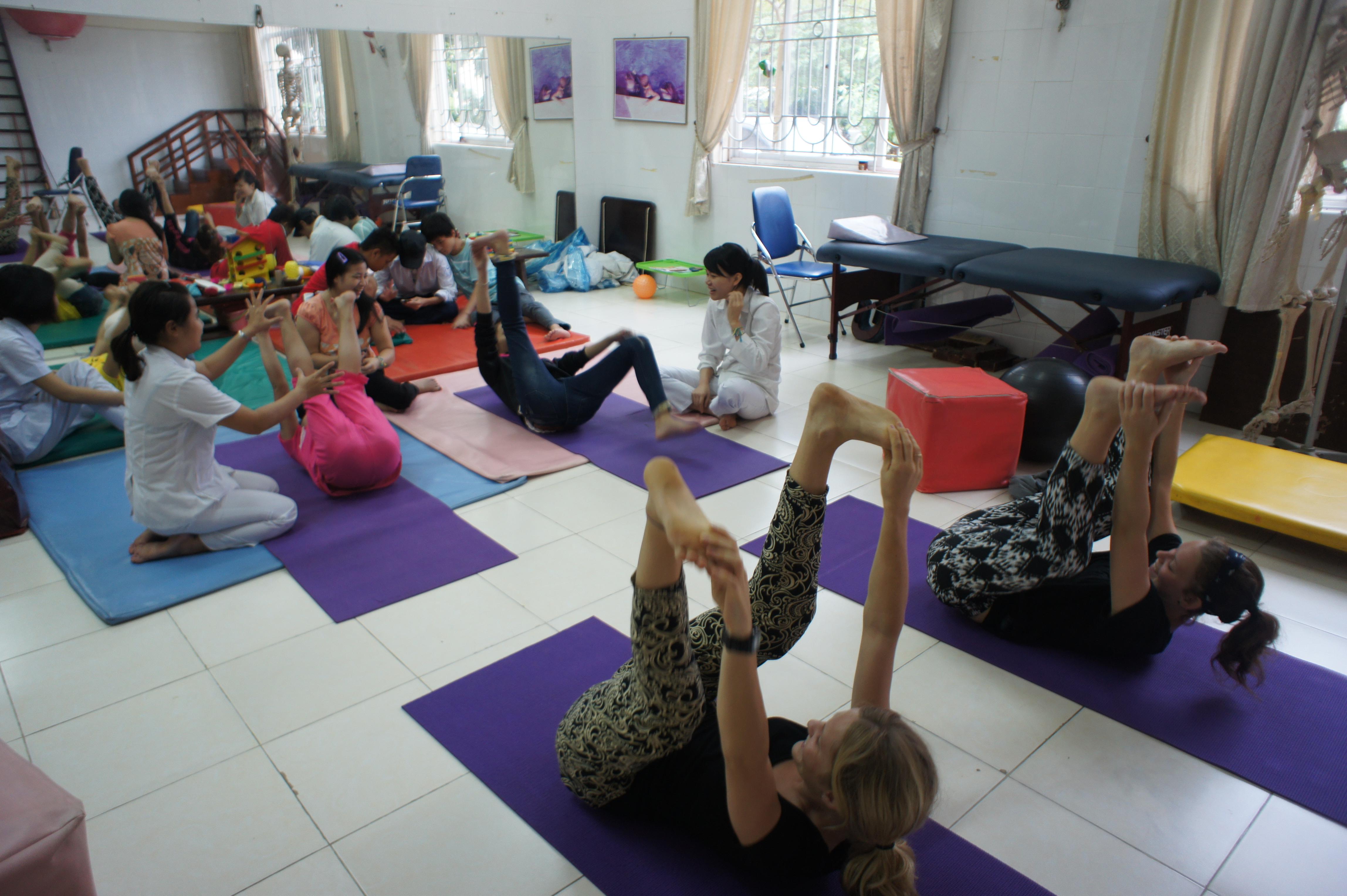 Projects Abroad interns leading a group with some stretching and basic exercises whilst on theri physiotherapy internship in Vietnam, Asia. Projects Abroad interns are pictured leading a stretching and exercising class whilst on their physiotherapy internship in Vietnam, Asia.